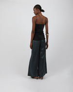 Load image into Gallery viewer, Woman wearing a black sleeveless silk top and patterned black pants