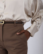 Load image into Gallery viewer, Paradisefold Person wearing a champagne silk shirt and brown pants with a white background