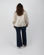 Load image into Gallery viewer, Paradisefold Person wearing a champagne silk blouse and jeans on a white background