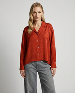 Load image into Gallery viewer, Woman wearing a red silk blouse and gray pants on a plain background
